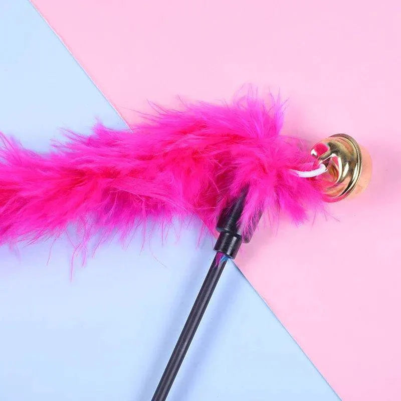 Cat teaser wand with pink feather and bell for interactive play.