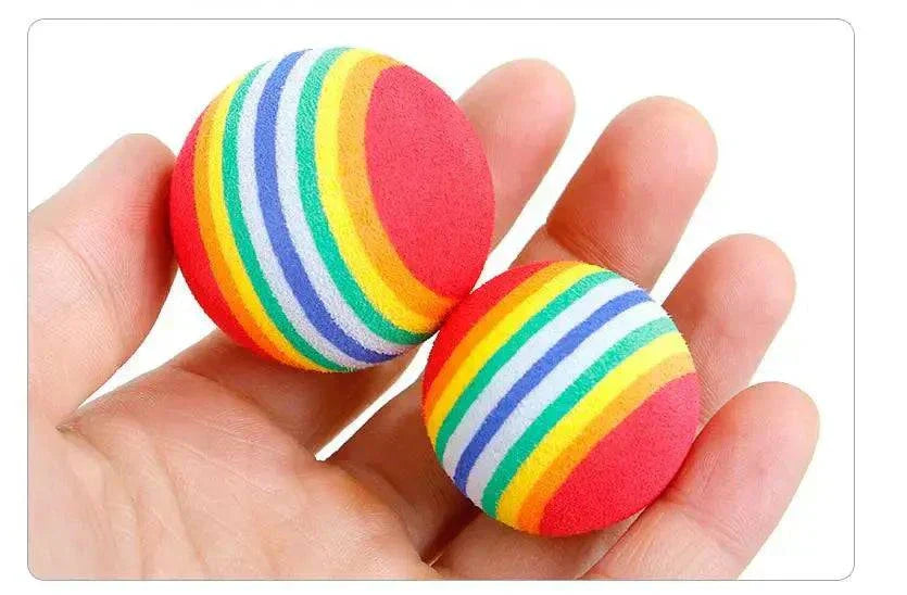 Catnip teeth-grinding toy for cats, rainbow plush chew balls in hand.