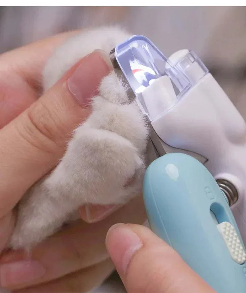 LED pet nail clippers trimming a small animal's paw.