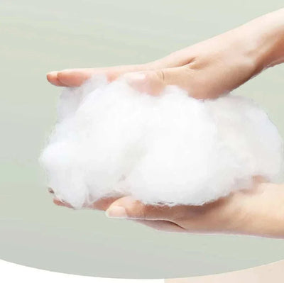 Hands holding soft white cotton for pet bedding.