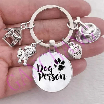 Cute dog paw keychain with glass pendant and silver charms featuring pet-themed designs.