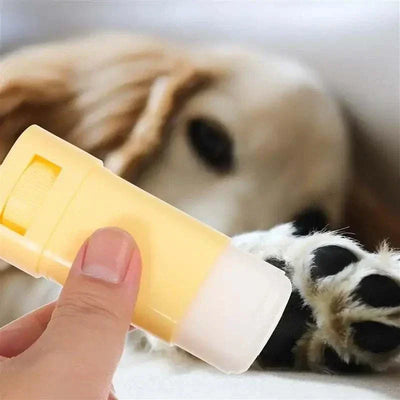 Pet paw balm stick being held near a dog's paw. Moisturizer Paw Balm for Pet Care