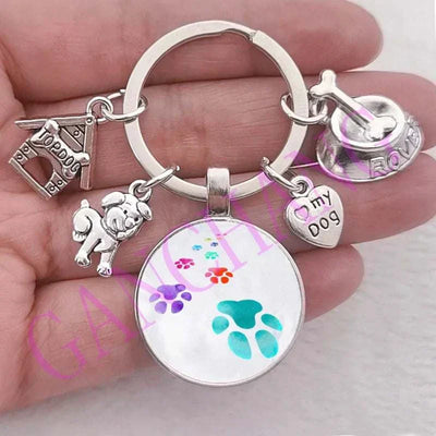 Cute dog paw keychain with glass pendant, antique silver-plated, unisex fashion accessory.