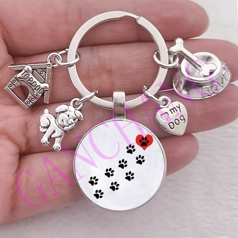 Cute dog paw keychain with glass pendant featuring charms and antique silver finish.