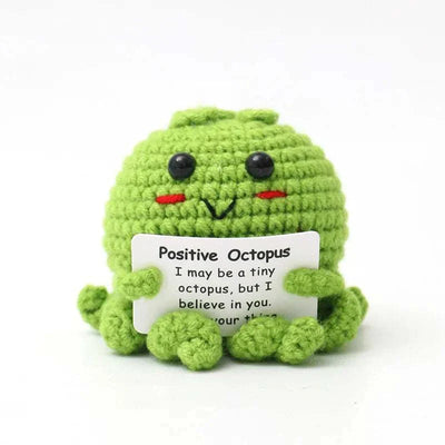 Handwoven crochet green octopus ornament holding a positive message card.